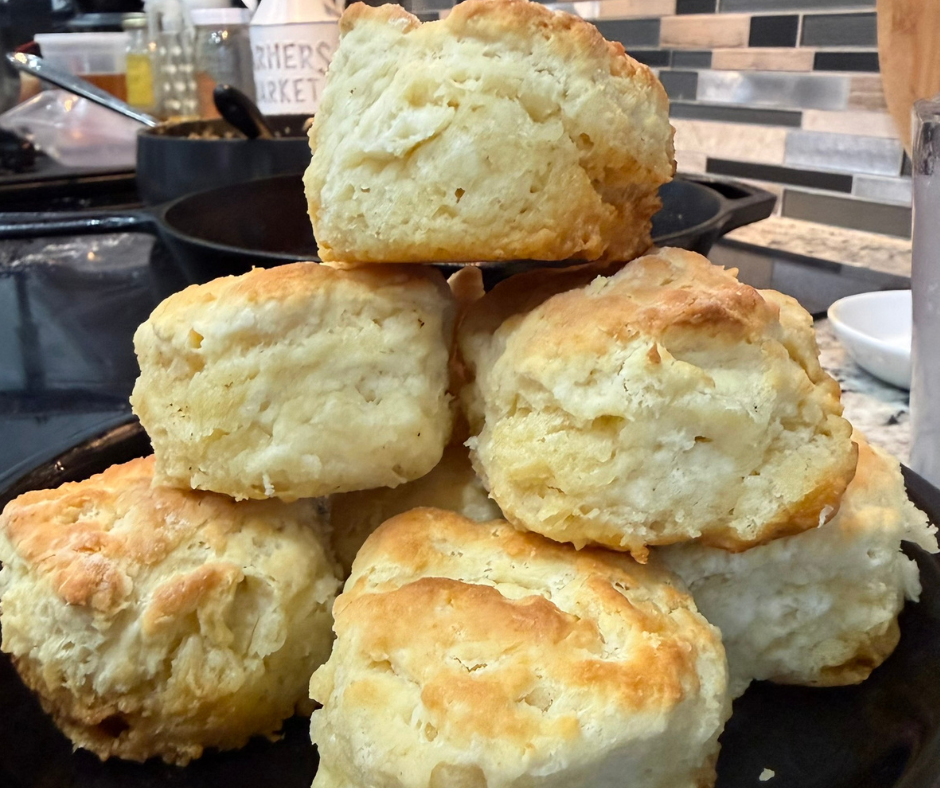 Freshly baked fluffy homemade butter biscuits with golden tops served warm on a plate
