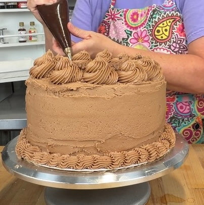 chocolate cream cheese frosting on a huge cake 